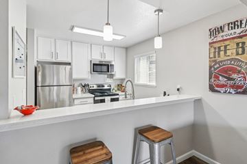 San Jose apartment for rent - A kitchen with white cabinets and a fridge.