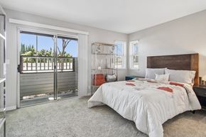 San Jose apartment for rent - A bedroom with a large bed and a sliding glass door leading to a balcony.