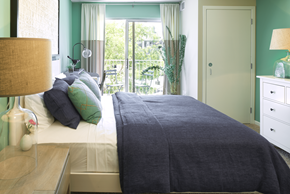 Woodbury apartment for rent - a bedroom with green walls and a bed with a gray blanket