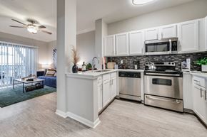 Houston apartment for rent - Three-Bedroom Luxury Apartments in Montrose, Houston, TX - The Maroneal - Kitchen with Stainless Steel Appliances, Tile Backsplash and Countertops, and Open Space to the Living Room.