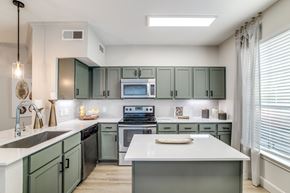 Houston apartment for rent - Washington Avenue Coalition, TX, Luxury Apartments Near Rice University - Marcella Memorial Heights - A Kitchen With Sage-Green Cabinetry, Stainless Steel Appliances, And A Large Window.