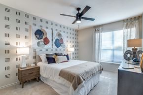 Houston apartment for rent - Dog-Friendly Luxury Apartments In Washington Avenue Coalition, TX - Marcella Memorial Heights - A Bedroom With Two Matching Bedside Tables, Ceiling Fan, And A Large Window.