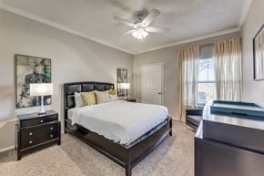 Austin apartment for rent - a bedroom with a large bed and a ceiling fan