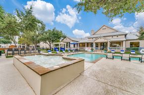 Austin apartment for rent - Two-Bedroom Apartments in Austin, TX - Parkside Crossing - Swimming Pool with Raised Bubbly Hot Tub, Lounge Chairs, Pergola, High-Top Table, Bar Stools, Metal Fence, and Trees.