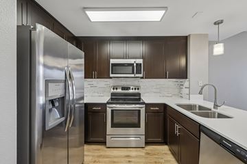 Walnut Creek apartment for rent - A modern kitchen with dark brown cabinets and stainless steel appliances.