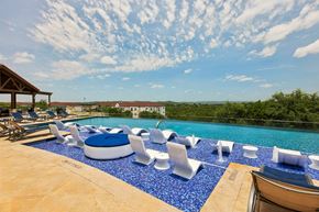 Austin apartment for rent - A pool with blue tiles and white chairs.