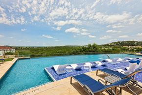 Austin apartment for rent - A large swimming pool with lounge chairs and a view of the countryside.