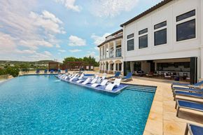 Austin apartment for rent - A large swimming pool with lounge chairs and a building in the background.