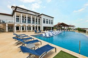 Austin apartment for rent - A pool with lounge chairs and a building in the background.