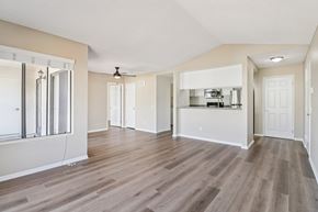 San Diego apartment for rent - A spacious room with wood flooring and a ceiling fan.