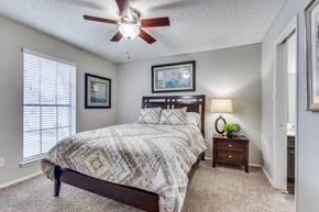 Austin apartment for rent - A bedroom with a bed, nightstand, and two pictures on the wall.