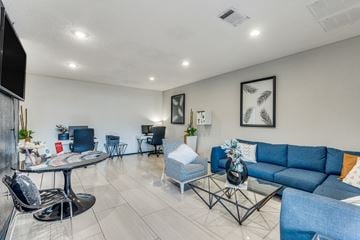 Austin apartment for rent - A living room with a blue couch and a glass table.