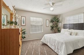 San Antonio apartment for rent - A bedroom with a bed, a dresser, and a ceiling fan.