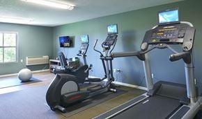 Woodbury apartment for rent - a gym with exercise equipment and televisions on the wall