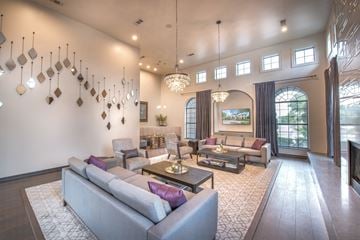Mckinney apartment for rent - A living room with a grey couch and a chandelier.