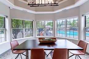 Bloomington apartment for rent - a dining room with a table and chairs with a view of a pool in the background