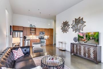 Nashville apartment for rent - a living room with a leather couch and a kitchen with wooden cabinets