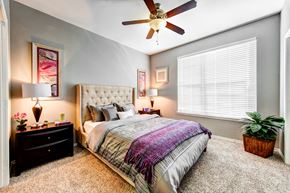 Round Rock apartment for rent - bedroom with large window and ceiling fan
