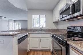 San Diego apartment for rent - 2-Bedroom Apartments in La Jolla, CA - Mirada at La Jolla Colony - Kitchen with Granite Countertops, White Cabinets, Wood-Style Flooring, and Stainless Steel Appliances