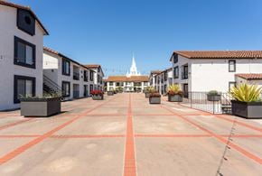 San Diego apartment for rent - an empty parking lot with buildings and a church in the background