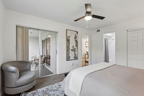 Sunrise apartment for rent - A bedroom with a large bed and a chair.