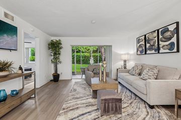 Sunrise apartment for rent - A living room with a couch, a coffee table, and a painting on the wall.