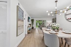 Sunrise apartment for rent - A dining room with a table set for two and a view of the backyard.
