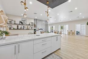 Sunrise apartment for rent - A modern kitchen with white cabinets and a marble countertop.