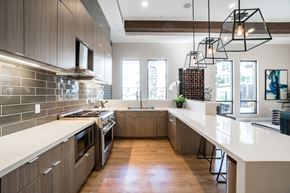 Santa Clara apartment for rent - One-Bedroom Apartments in Santa Clara, CA - Villas on the Boulevard - Entertainment Kitchen with Stainless Steel Appliances, Wood-Style Flooring, White Countertops, Title Backsplash, Wood-Style Cabinets, and Large Windows.