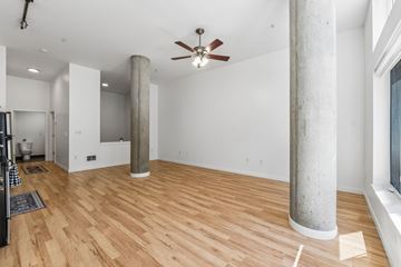 Seattle apartment for rent - A room with wooden floors and a ceiling fan.