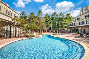 Houston apartment for rent - Washington Avenue Coalition, TX, Luxury Apartments Near Upper Kirby - Marcella Memorial Heights - A Swimming Pool Surrounded By Elegant Buildings, Lush Landscaping, And Sun Loungers.