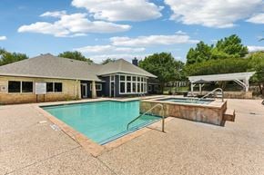 Round Rock apartment for rent - A pool with a slide and a building behind it.