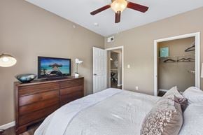 Round Rock apartment for rent - A bedroom with a large bed and a ceiling fan.