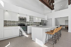 San Clemente apartment for rent - A modern kitchen with white cabinets and a stone backsplash.