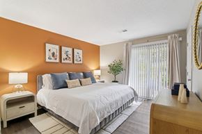 Marietta apartment for rent - A bedroom with a large bed, a nightstand, and a window with curtains.