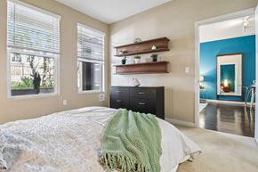 Santa Clara apartment for rent - Pet-Friendly Apartments in Santa Clara, CA - Villas on the Boulevard - Bedroom Suite With Plush Carpet, Desk Nook, Bedside Lighting, Abstract Wall Art, And Direct Hallway View To Bathroom Vanity.
