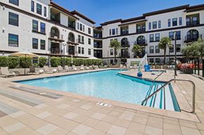 Santa Clara apartment for rent - A large swimming pool in front of a building with a blue sky in the background.
