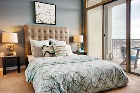 Arlington apartment for rent - A bedroom with a large bed and a view of the balcony.