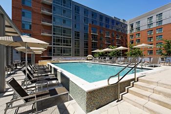 Sparkling rooftop pool with chaise lounges and cabana-style seating