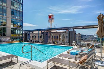 Sparkling rooftop pool with chaise lounges and cabana-style seating