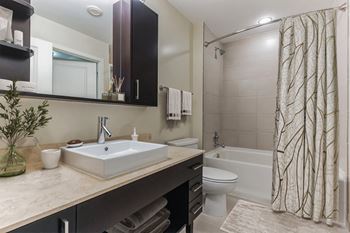 Marble countertops and raised vessel sinks in baths
