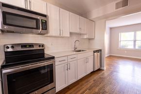 St. Louis apartment for rent - a kitchen with white cabinets and stainless steel appliances