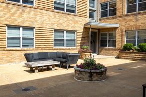 St. Louis apartment for rent - a patio with a couch and a table in front of a building