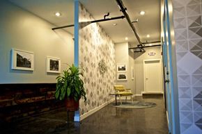 St. Louis apartment for rent - A hallway with a plant, pictures, and a yellow chair.