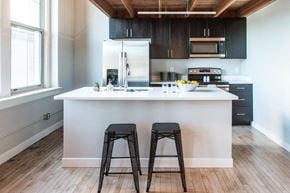 St. Louis apartment for rent - A kitchen with a white island and black stools.