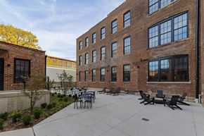 St. Louis apartment for rent - A courtyard with a table and chairs surrounded by brick buildings.