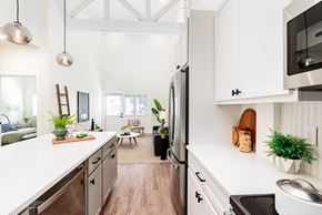 St. Louis apartment for rent - A modern kitchen with white cabinets and stainless steel appliances.