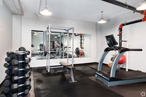 St. Louis apartment for rent - A gym with a treadmill, weight rack, and mirrors.