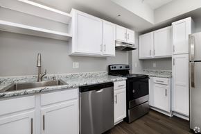 St. Louis apartment for rent - A kitchen with white cabinets and a granite countertop.