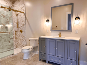 Pittsfield apartment for rent - A bathroom with a marble shower, a toilet, a sink and a cabinet.